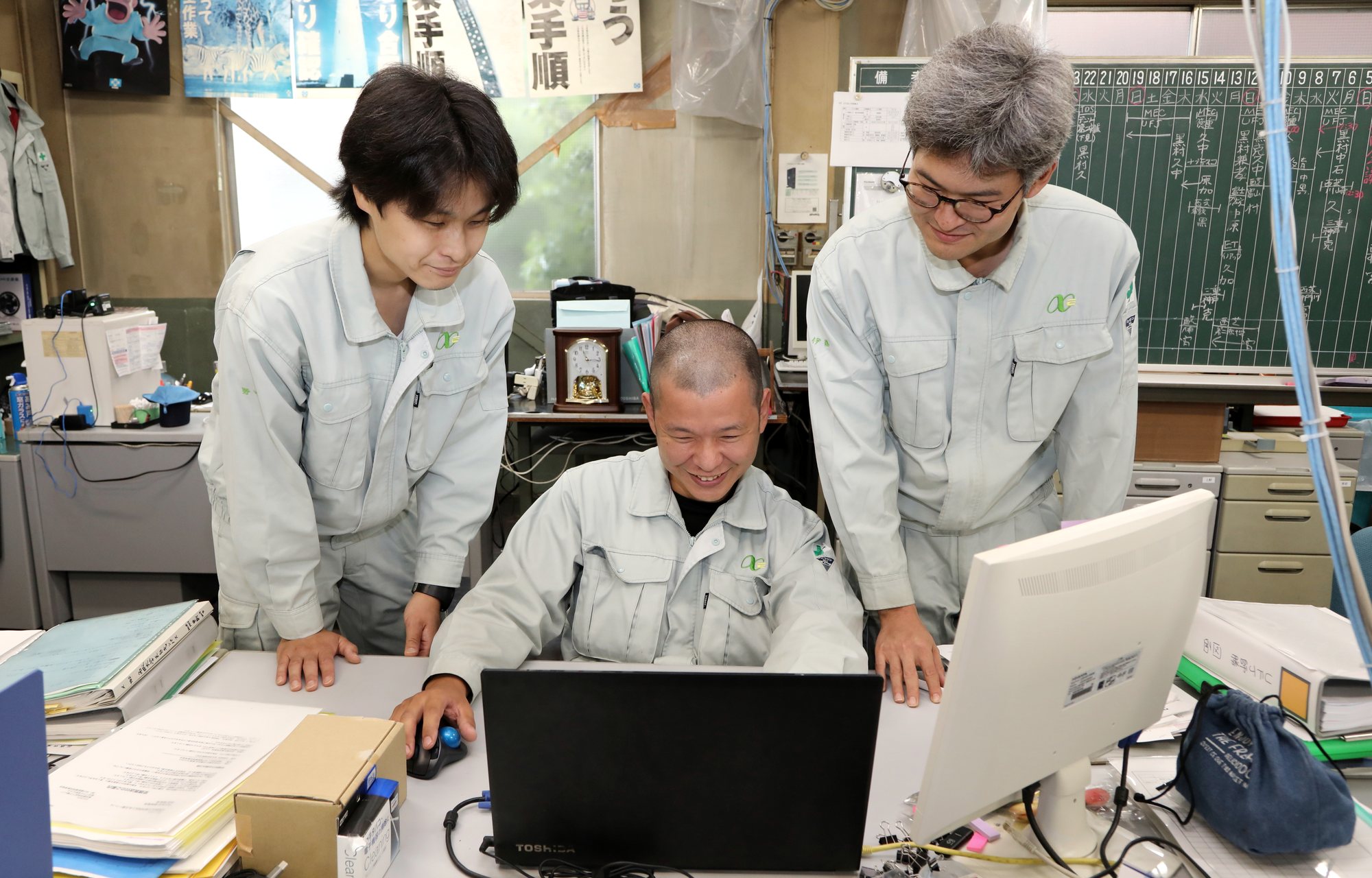 画面を囲んで検討する技術者たち